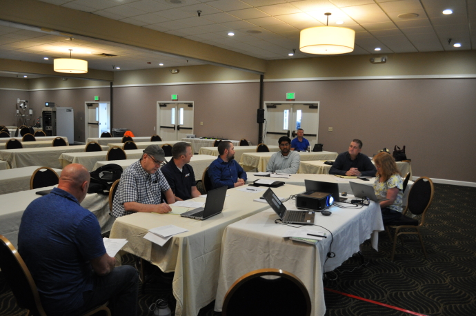 Group of people around tables; clockwise from left, Jim Whalen, Sean Campbell, Tyler Laing, Jeremiah Pearce, Karthik Murthy, Tony Leingang, Leann Koon