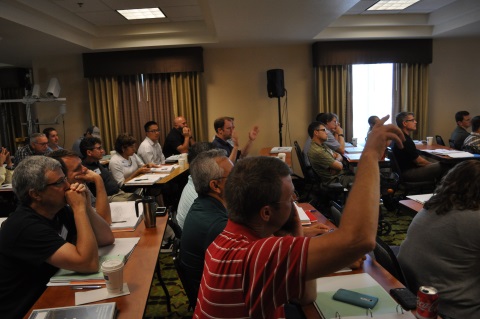 One of the more unique aspects of the Western States Forum is that questions and discussion are encouraged throughout the presentation, not just at the end. Here, several individuals have their hands raised to ask a speaker a question during the annual WSRTTIF.