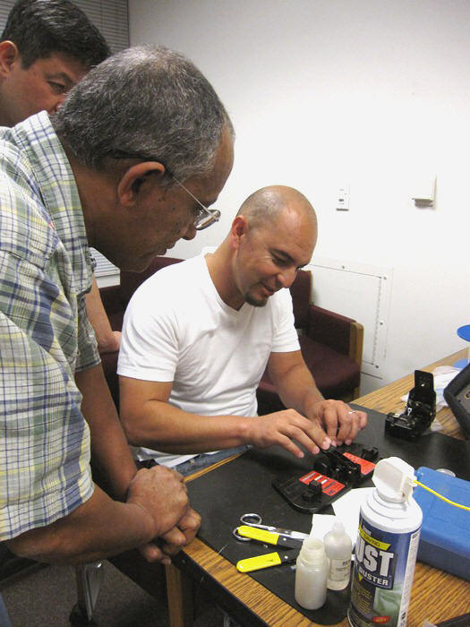 Samuel Campos (District 6) gets the fibers placed correctly to perform a successful mechanical splice.  Berhanu Zergaw observes.