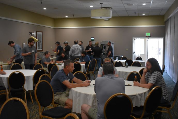 Forum attendees gather around tables, speaking to one another.